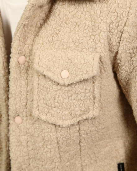 Close-up of a beige teddy jacket with button details